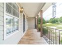 Covered front porch featuring wood decking, metal railing, and decorative lights for curb appeal at 1623 Pratt Rd, Covington, GA 30014