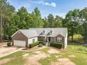 Aerial front view of a charming brick home with a two-car garage, manicured lawn, and lots of trees at 1623 Pratt Rd, Covington, GA 30014