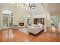 Open-concept living room features hardwood floors, fireplace, and arched windows to the outdoor porch at 115 Windover Ct, Roswell, GA 30075