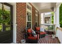 Inviting front porch with brick flooring, comfortable seating, and a welcoming wreath on the front door at 623 Brennan Dr, Decatur, GA 30033