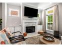 Cozy living room featuring a marble fireplace, built-in cabinets, and large windows for ample natural light at 623 Brennan Dr, Decatur, GA 30033