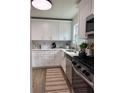 Updated kitchen featuring white cabinets, stainless steel appliances, and hardwood floors at 5674 Kingsport Dr # 4, Atlanta, GA 30342