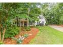 View of charming home with lush lawn and landscaping, mature trees offering shade and curb appeal at 5767 Wembley Dr, Douglasville, GA 30135