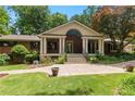 Charming brick home with a covered porch, landscaped front yard, and a patterned concrete driveway at 431 Keeler Woods Nw Dr, Marietta, GA 30064