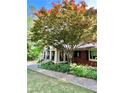 Charming brick home with covered porch, American flag, and beautiful mature tree in front yard at 431 Keeler Woods Nw Dr, Marietta, GA 30064