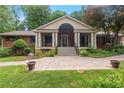 Inviting brick home with a covered porch, landscaped front yard, and patterned concrete driveway at 431 Keeler Woods Nw Dr, Marietta, GA 30064