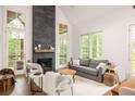 Bright living room with stone fireplace, vaulted ceiling, and large windows showcasing wooded views at 385 Anders N, Chattahoochee Hills, GA 30268