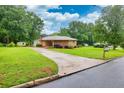 Well-maintained brick home with a long driveway and spacious front yard, surrounded by trees at 8140 Wood St Se, Covington, GA 30014
