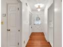 Entry hallway featuring hardwood floors, neutral walls, and classic lighting fixtures at 8140 Wood St Se, Covington, GA 30014