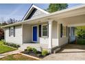 Detailed shot of a home's entrance showing a blue door, well-maintained landscaping, and an attached carport at 1450 Walker Se St, Smyrna, GA 30080