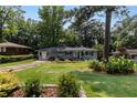Well-manicured front yard of a charming single-story home with mature trees and lush landscaping at 553 Collingwood Dr, Decatur, GA 30032