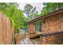 Backyard brick house featuring a wooden deck that leads to a refreshing in-ground pool for outdoor relaxation at 3553 Lakeview Dr, Rex, GA 30273