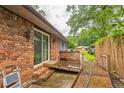 Brick house backyard showcasing a wooden deck, brick features, and a tranquil outdoor space at 3553 Lakeview Dr, Rex, GA 30273
