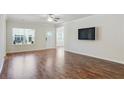 Bright living room featuring hardwood floors, ample natural light, and a wall-mounted TV, perfect for relaxation and entertainment at 3891 Shelleydale Dr, Powder Springs, GA 30127