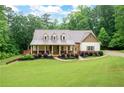 Beautiful single Gathering home with a sprawling green lawn and mature trees in the background at 7131 Ridge Rd, Hiram, GA 30141