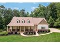 Inviting two-story home with a covered front porch, dormers, and manicured lawn at 7131 Ridge Rd, Hiram, GA 30141