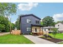 Two-story home with vertical siding, a well-manicured lawn, and a paved driveway at 1129 Victory Sw Dr, Atlanta, GA 30310