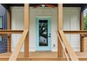 A close-up view of a front door with a light blue frame and wood porch at 1129 Victory Sw Dr, Atlanta, GA 30310