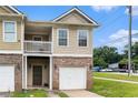 Charming townhouse showcasing brick accents, an attached garage, and a covered balcony at 2996 Jonesboro Road Southeast Se Rd # J, Atlanta, GA 30354