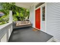 Inviting porch with a porch swing and vibrant red door, surrounded by lush greenery and privacy at 797 Ashland Ne Ave, Atlanta, GA 30307