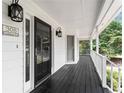 Close up of a lovely covered porch featuring dark wood floors and white trim at 308 Golden Ct, Canton, GA 30114