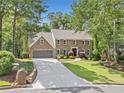 Charming two-story brick home with an attached garage, long driveway, and mature trees at 335 S Satinwood Pl, Roswell, GA 30076