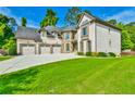 Beautifully landscaped front lawn leading up to a two-story brick home with a three-car garage at 5121 Hope Sw Ct, Lilburn, GA 30047
