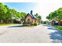 Community entrance with brick gate house and wrought iron gates, surrounded by mature trees at 5121 Hope Sw Ct, Lilburn, GA 30047