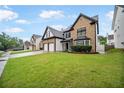 Charming two-story home with stone and siding, well-manicured lawn, and a two-car garage at 773 Minor Oaks Nw Run, Lilburn, GA 30047