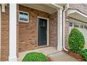 Inviting entryway featuring a black front door, brick exterior, and lush landscaping at 218 Ellis Ln, Woodstock, GA 30189