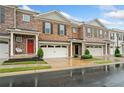 Attractive townhome featuring brick facade, one-car garage, and well-maintained landscaping at 218 Ellis Ln, Woodstock, GA 30189