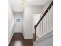 Bright foyer with hardwood floors and a staircase featuring white risers and a dark wood handrail at 218 Ellis Ln, Woodstock, GA 30189