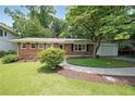 Charming brick home with well-manicured lawn, mature trees, and a convenient one-car garage at 2394 Burch Ne Cir, Brookhaven, GA 30319