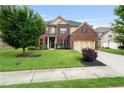Lovely two-story brick home with a well-manicured lawn, mature trees, and a two-car garage at 3352 Stone Point Way, Buford, GA 30519