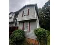 This exterior image shows a side view, highlighting the gray siding and red framed windows at 5568 Bradley Cir, Lithonia, GA 30038