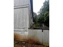 This rear exterior shows the aging gray siding and the lower level vents of the house at 5568 Bradley Cir, Lithonia, GA 30038