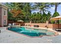 Enjoy the backyard pool with a tanning ledge, spa, and outdoor kitchen and lounge area at 8295 St Marlo Fairway Dr, Duluth, GA 30097