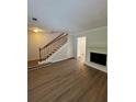Open living room with a classic fireplace, wooden staircase and laminate floors at 2435 Northlake Ct, Atlanta, GA 30345