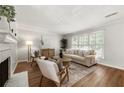 Open living room features a cozy fireplace, hardwood floors, neutral colors, and lots of sunlight at 2435 Northlake Ct, Atlanta, GA 30345