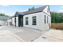 Side view of a charming, white home featuring black trim and a concrete driveway at 3175 Dogwood Dr, Atlanta, GA 30354
