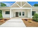 Inviting front porch with modern farmhouse design details, decorative columns, and a welcoming entrance at 4824 Se Highway 20, Conyers, GA 30013