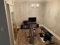 Home gym featuring a chandelier, weights, shelving, television, barstool and exercise equipment at 5570 Chemin De Vie, Atlanta, GA 30342