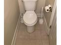 Compact toilet area featuring neutral tile flooring and white toilet at 5570 Chemin De Vie, Atlanta, GA 30342