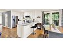 Bright, open kitchen featuring white cabinets, stainless appliances, and a breakfast bar with hardwood floors at 230 Channings Lake Dr, Lawrenceville, GA 30043