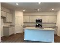 A kitchen with an island, gray cabinets and granite countertops at 1001 Limburg Dr, Hampton, GA 30228