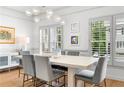 Bright dining room with modern light fixture, plantation shutters, hardwood floors and seating for six at 208 Wade Creek Rd, Alpharetta, GA 30009