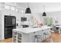 Stylish kitchen with an oversized island, stainless steel appliances, white cabinets, and a breakfast bar with seating at 208 Wade Creek Rd, Alpharetta, GA 30009