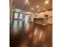 Hardwood floors leading into an open-concept kitchen with stainless appliances, white cabinets, and stone countertops at 2778 Wild Laurel Ct, Norcross, GA 30071