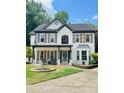 Inviting two-story home with covered front porch and mature landscaping in a residential neighborhood at 710 Oxford Crest Ct, Lawrenceville, GA 30043