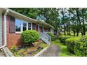Brick home with a welcoming porch, complemented by lush greenery and a sidewalk at 766 Virginia Cir, Forest Park, GA 30297